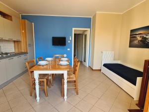 a dining room with a table and chairs and a bed at Villaggio Mietta in Castiglioncello