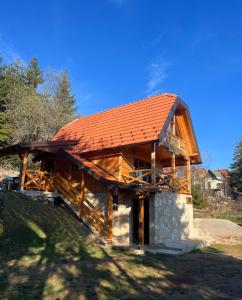 a large wooden building with an orange roof at Brvnara Tarska Zora in Sekulić 