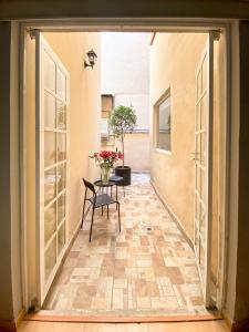 Drzwi otwarte prowadzące na patio ze stołem w obiekcie Casa Condesa Amatlan 84 w mieście Meksyk