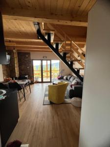 a living room with a staircase in a house at Brvnara Tarska Zora in Sekulić 