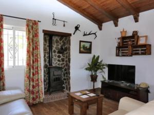 sala de estar con sofá y chimenea en Casa para Familias con piscina y Barbacoa, en Conil de la Frontera