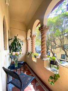 uma varanda com uma mesa e cadeiras e uma janela em Casa Condesa Amatlan 84 em Cidade do México