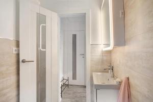 bagno bianco con lavandino e specchio di Ferienwohnung Erhardt a Günzburg