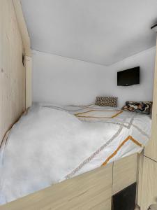 um pequeno quarto com uma cama no canto em Le coin cosy d'Anglet em Anglet