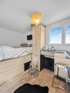 um quarto com uma cama e uma cozinha com um lavatório em Le coin cosy d'Anglet em Anglet