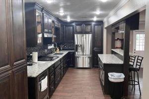 a kitchen with wooden cabinets and a stainless steel refrigerator at Pool/ Outdoor kitchen/Pool table in Houston