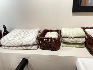 tre cesti di vimini seduti su uno scaffale con asciugamani di The Farm Shed Guelph Elora a Guelph