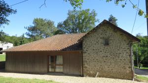 una antigua casa de piedra con techo rojo en Gite 20 places en Razès