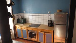 a kitchen with a stove and a refrigerator at Gite 20 places in Razès