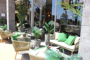a patio with chairs and plants in front of a store at Barceló Teguise Beach - Adults Only in Costa Teguise