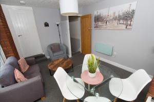 a living room with a couch and a table and chairs at Bloomfield Apartments in Blackpool