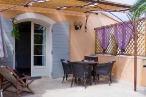 a patio with a table and chairs and a door at La treille in La Cadiere d'Azur