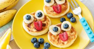 a yellow plate with pancakes with strawberries and blueberries at Il Villaggio Hotel Residence Lì Cylentos Elios a 100 mt dal mare cilentomarexperience in Policastro Bussentino