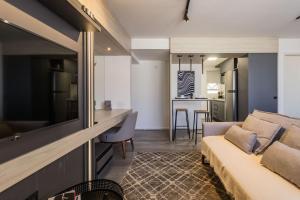 a living room and dining room with a couch at Duque by My Way - a 100 metros da Santa Casa e UFRGS in Porto Alegre