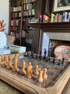 un tablero de ajedrez sobre una mesa en una sala de estar con chimenea en Le Château Isigny un joyau caché et secret près du Mont Saint-Michel en Normandie aux portes de la Bretagne, en Isigny-le-Buat