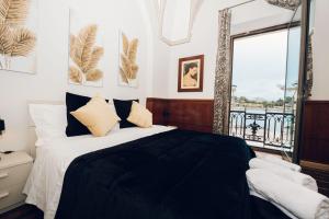 um quarto com uma cama em preto e branco e uma janela em Verso Oriente em Brindisi