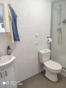 uma casa de banho branca com um WC e um lavatório em Gästhus, 45m2, lugnt, havsbad em Särö