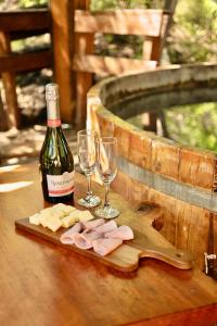 - une bouteille de vin et des verres à vin sur une table dans l'établissement Cabañas Bafemadi, à Las Trancas
