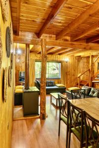 salon z drewnianymi ścianami i drewnianymi sufitami w obiekcie Cabañas Bafemadi w mieście Las Trancas