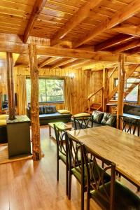 a living room with wooden ceilings and a table and chairs at Cabañas Bafemadi in Las Trancas +49 photos