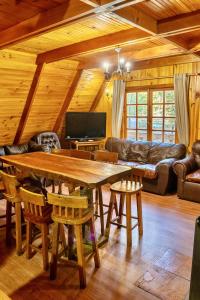 a living room with a wooden table and a couch at Cabañas Bafemadi in Las Trancas