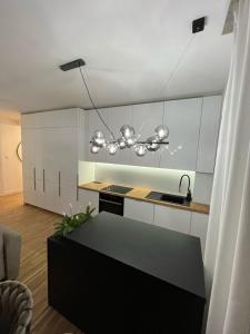 a kitchen with white cabinets and a black counter top at Apartamenty Cieszyn in Cieszyn
