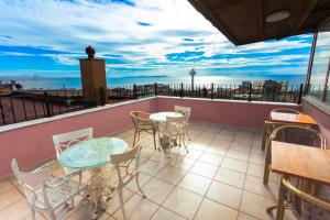 a balcony with tables and chairs and a view of the ocean at Hotel Tashkonak Istanbul in Istanbul