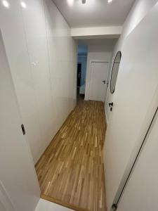 a hallway with white walls and a wooden floor at Apartamenty Cieszyn in Cieszyn