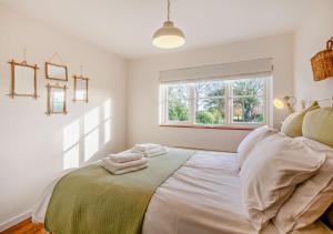 a bedroom with a bed with two towels on it at Bakers Cottage - Sidestrand in Sidestrand