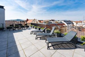 uma varanda com cadeiras e mesas num edifício em New Blue Danube Apartment with Balcony and Parking em Budapeste