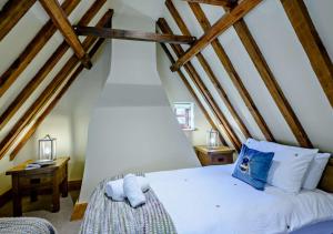 Panxworth的住宿－Holly Cottage，卧室配有带木梁的白色床