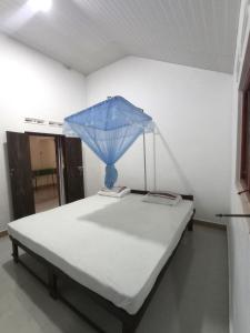 a bed with a blue umbrella on top of it at Bundala Resort in Tissamaharama