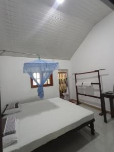 a bedroom with a bed with a blue cover on it at Bundala Resort in Tissamaharama