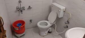 a bathroom with a toilet and a trash can at Jahangir Cottage Pahalgam in Pahalgām