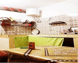 uma cozinha com uma mesa com um balcão verde em A room in a shared house for surfers2 em Safi