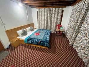 a bedroom with a bed in a room with curtains at Jahangir Cottage Pahalgam in Pahalgām