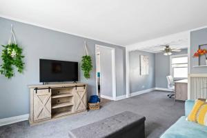 a living room with a tv and a couch at Norwood Park/Edison Park! Workstation & In-unit Laundry! 2nd Floor Apt in Chicago