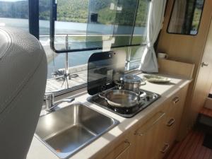 a kitchen with a sink and a stove in an rv at Koolhouse Boat in Vila Nova de Foz Coa