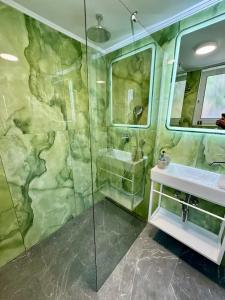 uma casa de banho com um chuveiro, um lavatório e um espelho. em Seafront Apartment em Karfas
