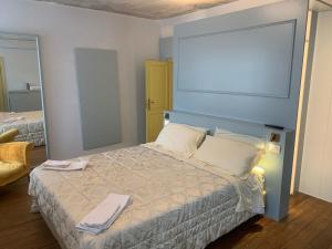 - une chambre avec un lit doté d'une tête de lit bleue dans l'établissement Villa San Liberale - Suites & Wellness, à Feltre