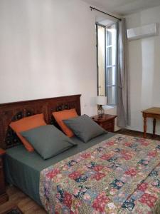 a bedroom with a bed with two pillows and a window at Côté fontaine in Orange