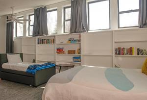 a bedroom with two beds and a book shelf at Meadowbrook Condos in Ketchum