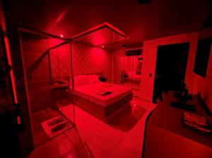 um quarto com uma cama e um quarto com luz vermelha em Prestige Motel 1 em São Paulo