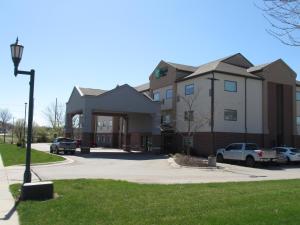 a large apartment building with cars parked in a driveway at Holiday Inn Express Hotel & Suites Lincoln South by IHG in Lincoln