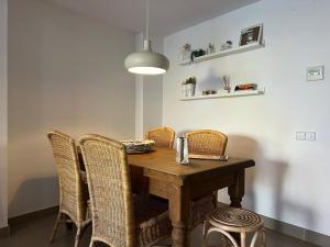 mesa de comedor con sillas de mimbre y lámpara en Ground floor apartment in Centre of Torroella De Montgri en Torroella de Montgrí