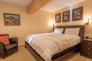 a bedroom with a bed and a chair at Cottonwood Condo 1474 in Sun Valley