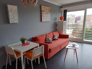 ein Wohnzimmer mit einem roten Sofa und einem Tisch in der Unterkunft Gaviota in Middelkerke