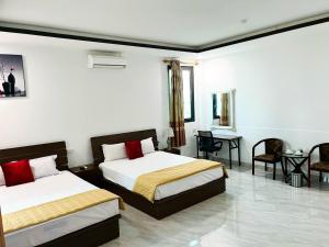 a hotel room with two beds and a table at Khách Sạn Đông Đô in Hai Phong
