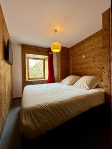 a bedroom with a large bed and a window at Le refuge in Valloire