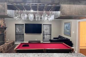 a living room with a red pool table and a tv at Pool/ Outdoor kitchen/Pool table in Houston